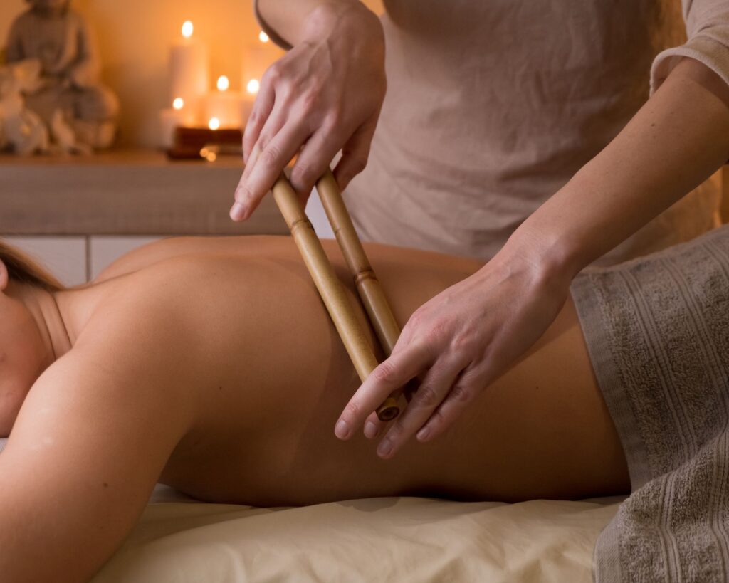 A personalized bamboo massage session illustrated, with a massage therapist holding heated bamboo sticks of various sizes, ready to provide tailored treatment for individual needs and preferences.