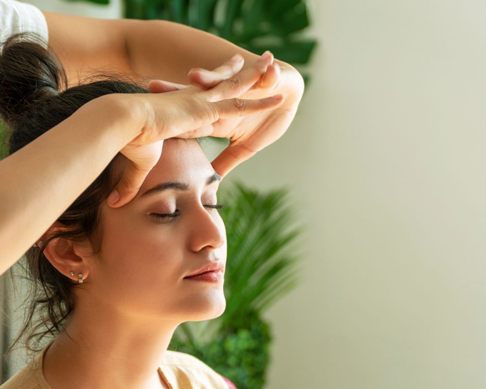 Peaceful client receiving calming head massage, showcasing the powerful mind-body connection of therapeutic touch