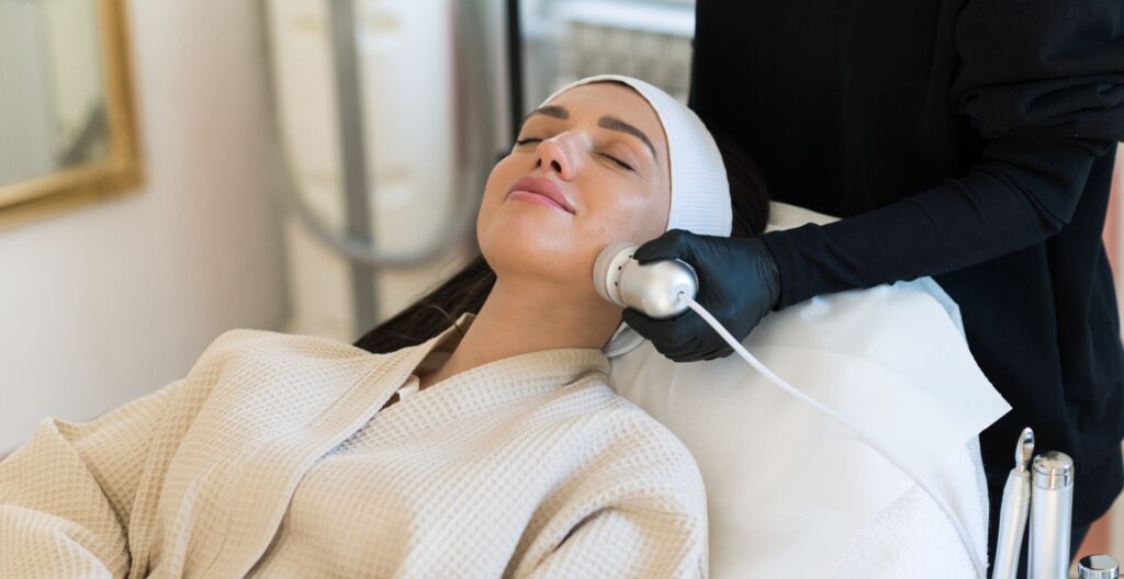 Aesthetician performing HydraFacial treatment with cleansing and hydration steps.