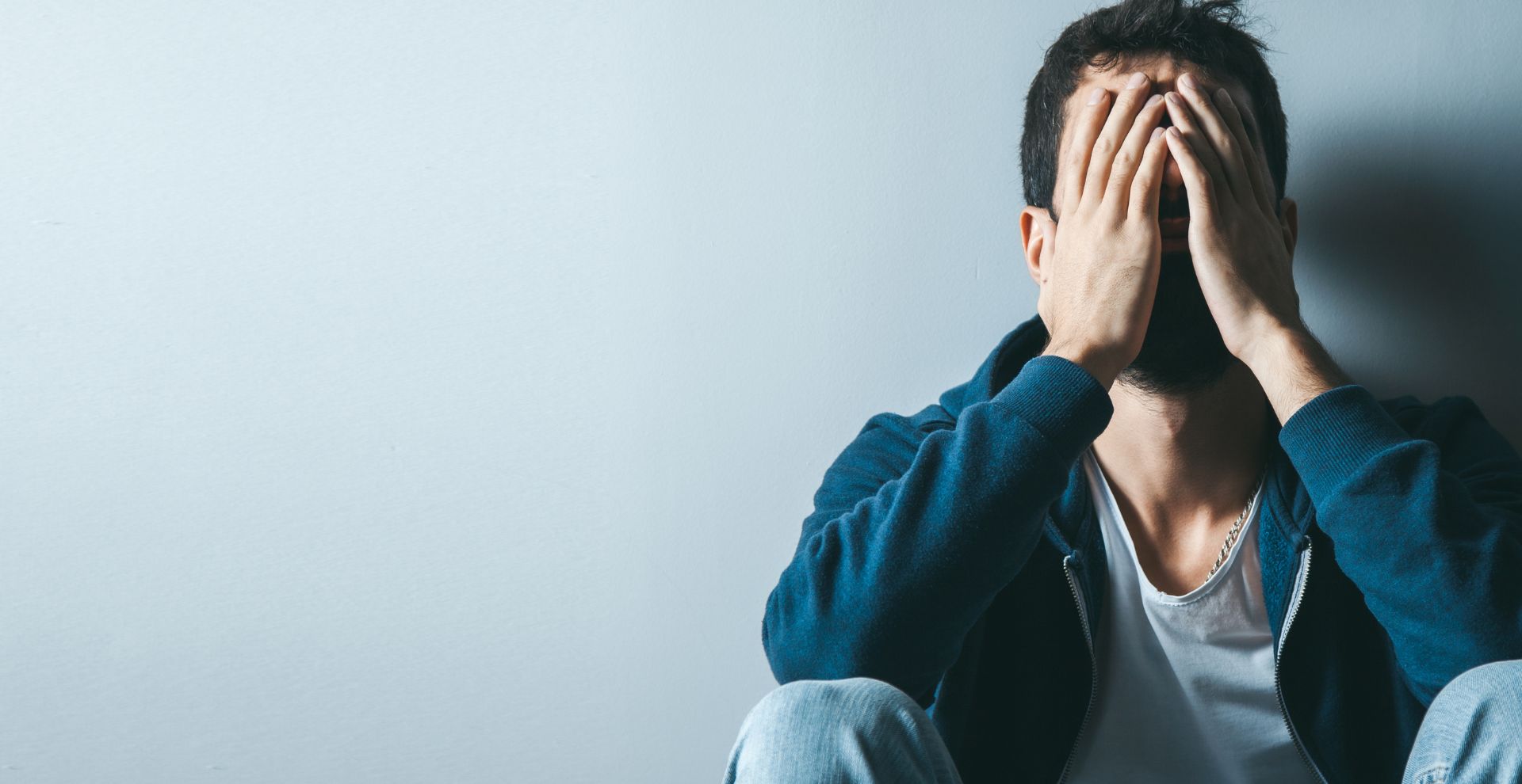 Man resting his face in his hand, showing signs of emotional tension and fatigue
