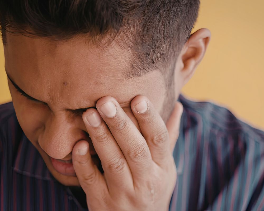 Close-up of a person holding jaw and temples, showing signs of facial tension and tightness