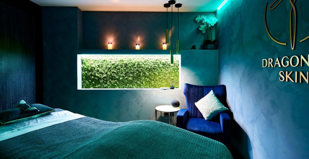 A calm, candlelit treatment room with a massage bed and soft towels at a Leeds day spa