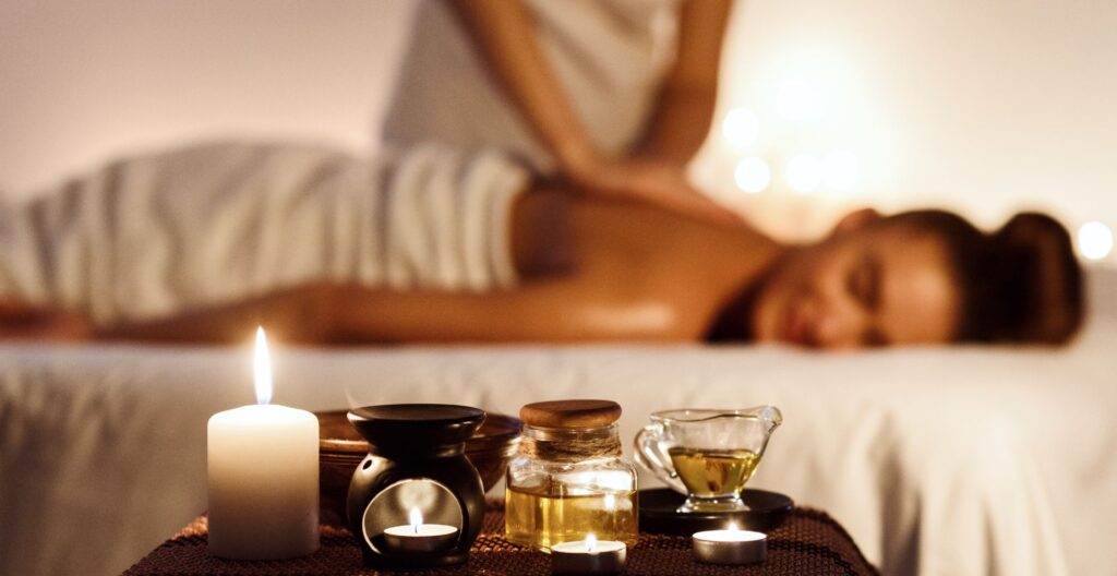Therapist smoothing warmed oil across a guest's back during an aromatherapy massage